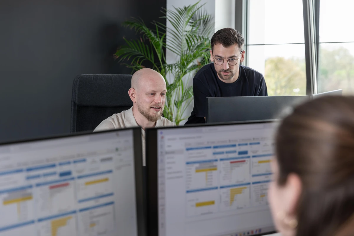 Managing Consultant Julian Ludt analysiert mit einem Kollegen ein semantischem Modell zur treiberbasierten Unternehmensplanung. Smarte Power BI Dashboards für exakte Klarheit